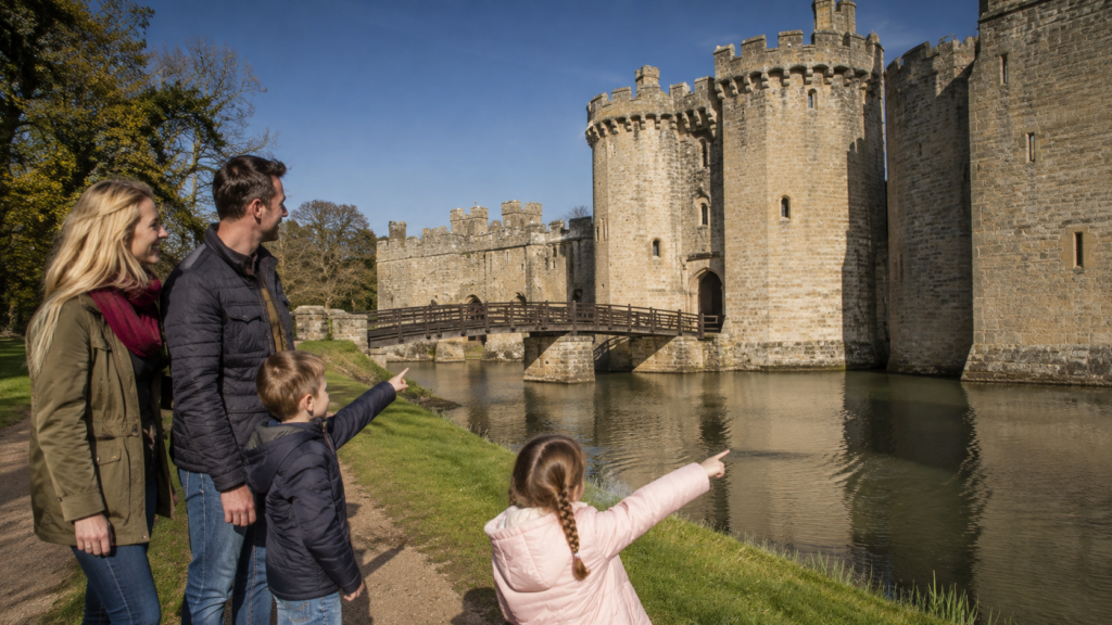 Family with two young children exploring the grounds of a UK castle on a sunny day